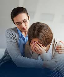 Mujer profesional brindando apoyo emocional y primeros auxilios psicológicos a una persona en crisis.